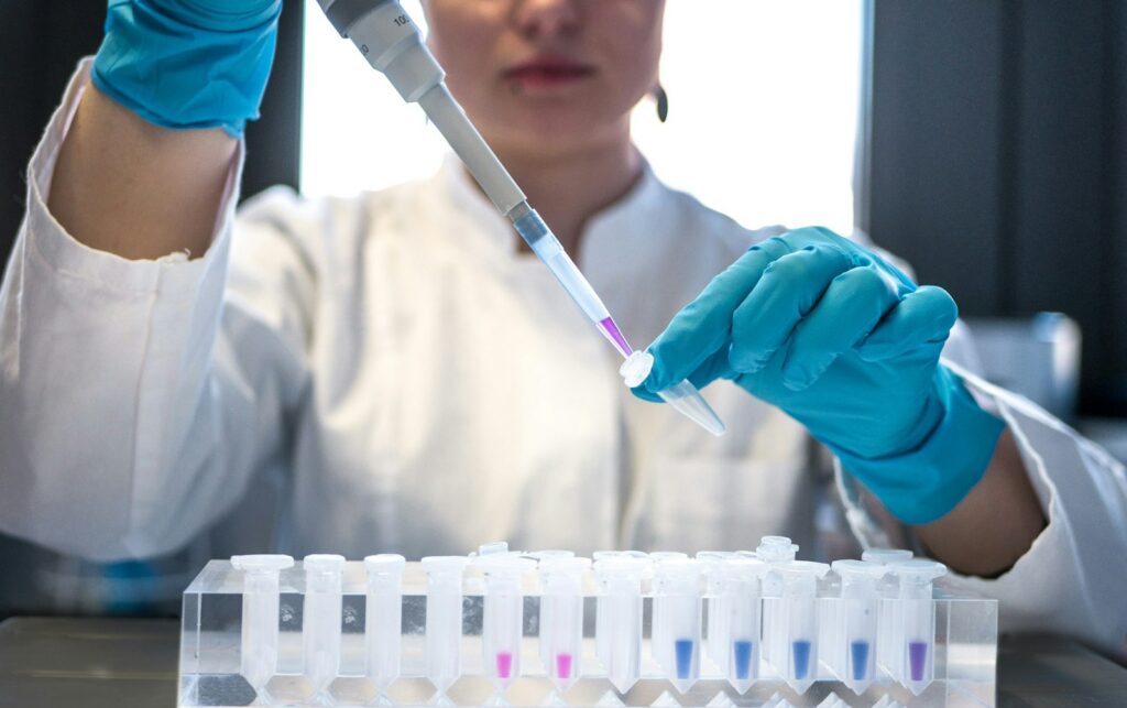 Lab researcher using a pipette with test tubes